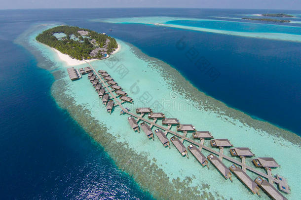 绿松石水中热带岛屿的鸟瞰图。 豪华的水上别墅在热带岛屿度假胜地马尔代夫度假。
