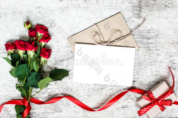 空白白色贺卡与红玫瑰花束，信封和礼品盒