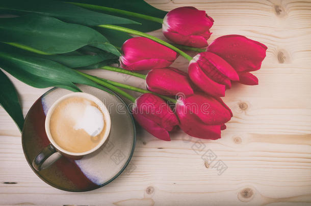 一杯咖啡与春花，红色郁金香在木桌上，复古风格