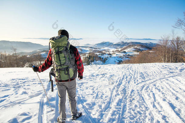 背包客徒步旅行在白雪覆盖的山上