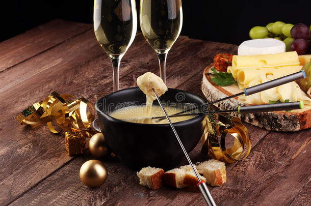 瑞士美食火锅晚餐在一个冬天的晚上与各种奶酪在一个板上，与一个加热的奶酪火锅与两个