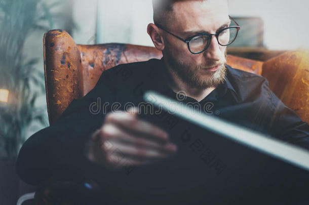坐在老式椅子上的智能商人阅<strong>读书籍</strong>的特写肖像。年轻的胡子的人在放松