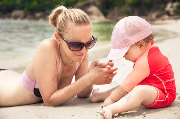 暑假期间孩子和妈妈在热带海滩玩耍