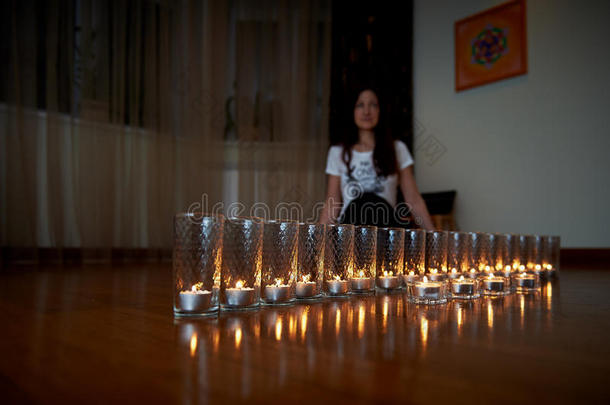 女孩在蜡烛的温<strong>暖灯</strong>光下做瑜伽和放松。 冥想