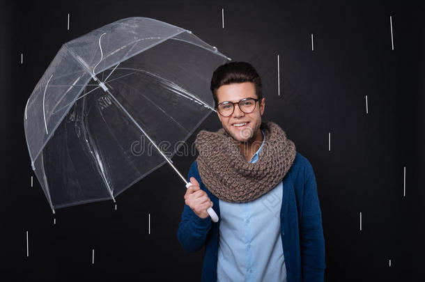 迷人的快乐男人拿着雨伞。