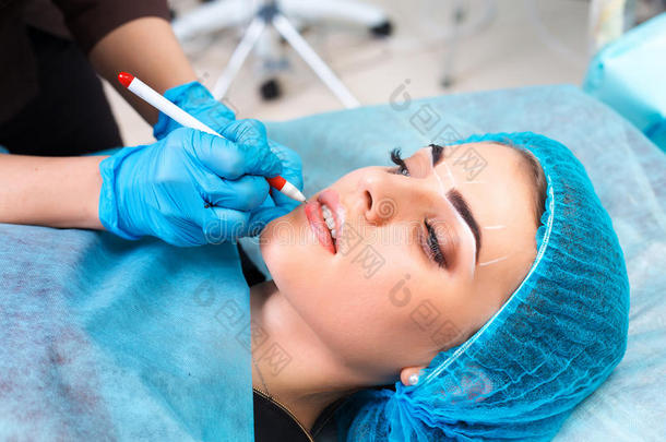 美容师在女人`脸上做永久的化妆