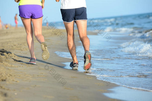 在阳光明媚的<strong>暑假假期</strong>，一对年轻夫妇的腿在海边沙滩上奔跑