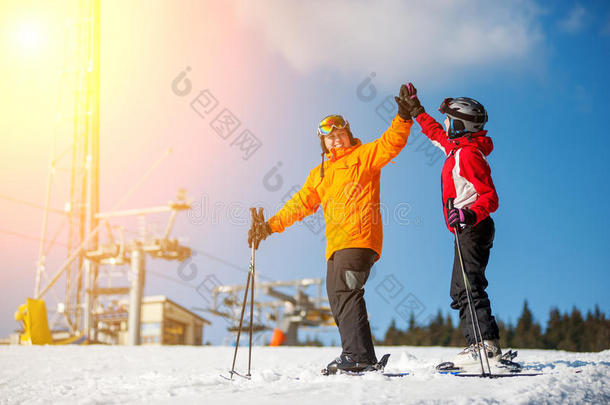 一对夫妇抱着滑雪板站在一个冬季度假胜地