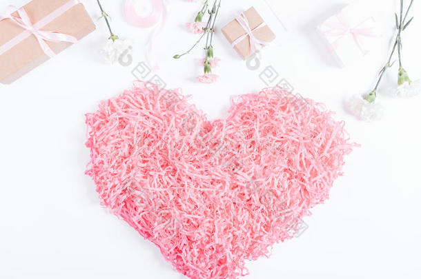 装饰粉红色的心，盒子里有礼物和鲜花，躺在白色的背景上