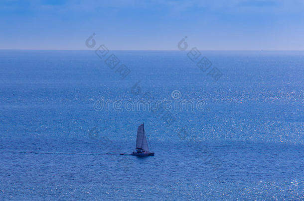 五颜六色的海洋景观与帆船对抗深蓝色的海洋