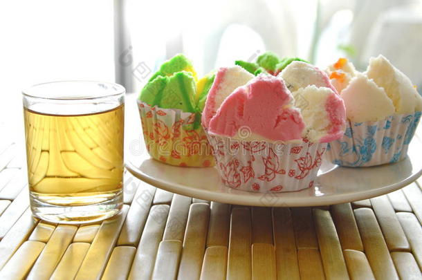 各种彩色棉纸蛋糕在盘子和茶上