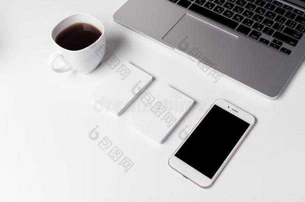 咖啡杯，名片和智能手机靠近笔记本电脑
