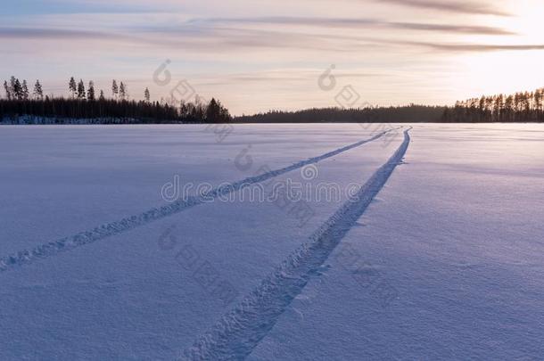 汽车轮胎在雪盖上的痕迹在一个湖上