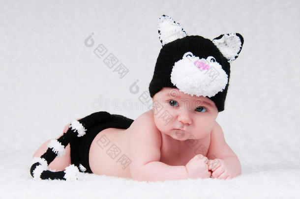 漂亮的婴儿穿着滑稽的服装，猫耳朵和尾巴。