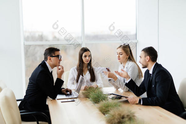 商务会议。 穿着正装的商人在一起坐在桌子旁讨论某事
