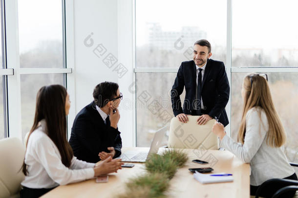 穿着正式服装的商人和领导者一<strong>起坐</strong>在桌子旁讨论一些事情