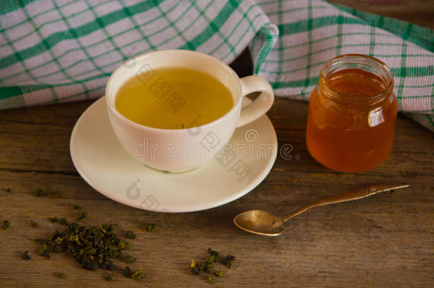 绿茶在<strong>一个</strong>白色的杯子和蜂蜜罐与<strong>勺子</strong>和绿色k