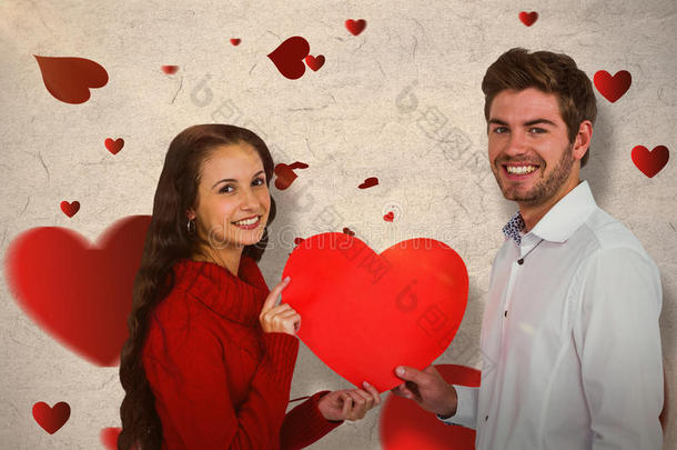 微笑夫妇抱着纸心的复合图像