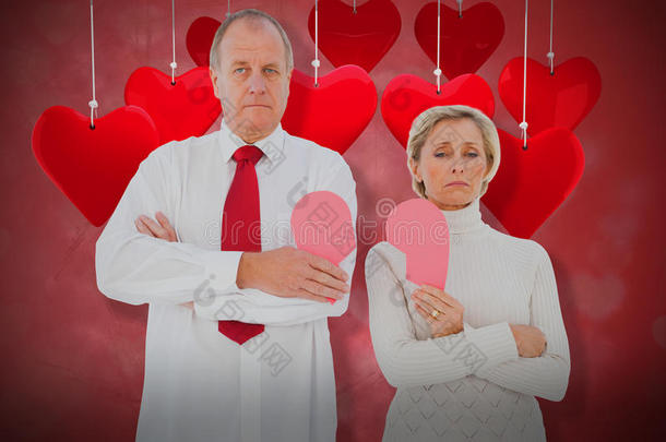 老年夫妇站立的复合图像，持有破碎的粉红色心脏3D