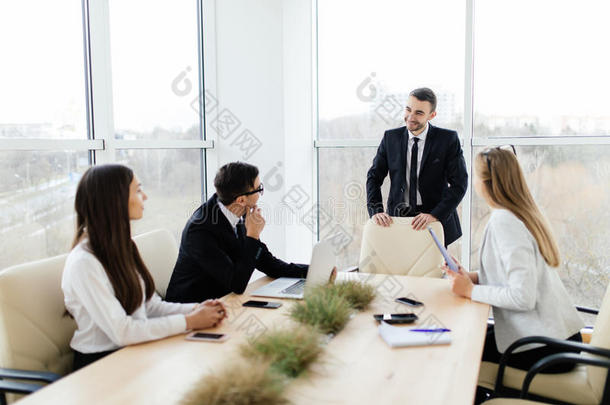 商务会议。 穿着正装的商人在一起坐在桌子旁讨论某事