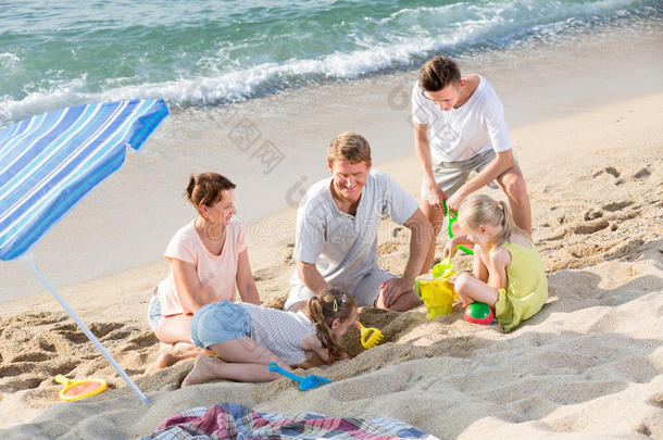 家庭里有四个孩子在海滩上玩耍