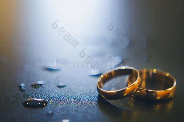 桌上有<strong>金色</strong>的结婚戒指和<strong>水滴</strong>