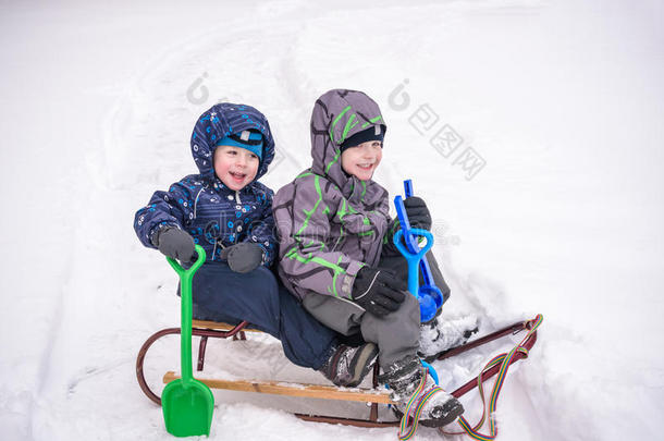 可爱的学龄前<strong>儿童</strong>在<strong>冬天</strong>穿坐在雪地里玩机智
