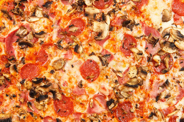 背景来自美味的经典意大利比萨饼，火腿，香肠，西红柿，蘑菇和奶酪