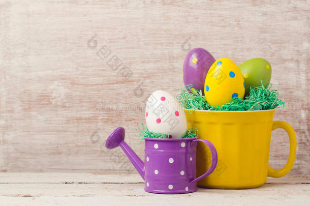 复活节假期概念与鸡蛋装饰在黄色杯和浇水罐