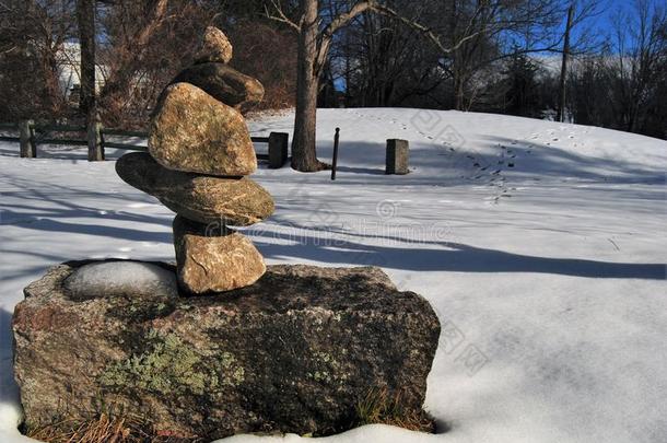 一个小小的岩石在一个雪覆盖的田野里排列在一个明亮的冬中天