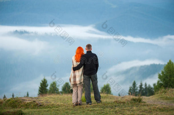 一对游客站在山上享受早晨的阴霾