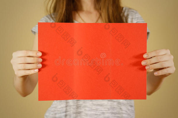 女孩展示空白的红色传单小册子。 小册子介绍。 小册子牵着手。 女人显示清晰的偏移纸。 床单