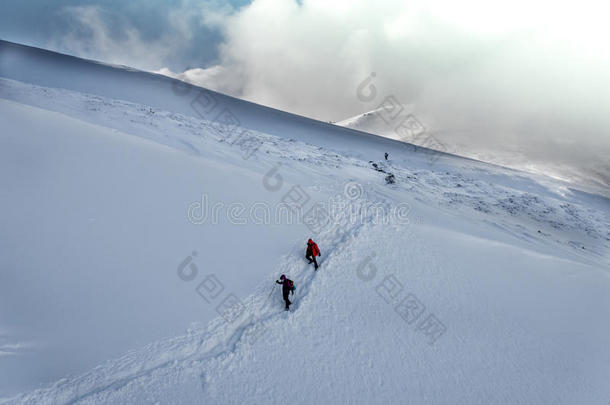 冬天集体徒步旅行在白雪覆盖的山上