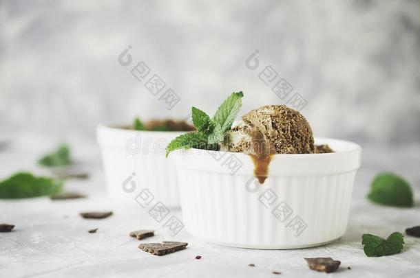 白碗巧克力薄荷冰淇淋，大理石桌上放着巧克力和薄荷叶