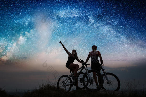 一对骑自行车的人晚上在星空下骑山地自行车