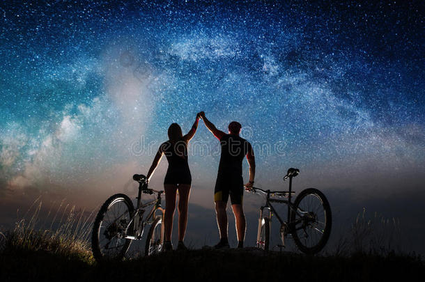 一对骑自行车的人晚上在<strong>星空下</strong>骑山地自行车