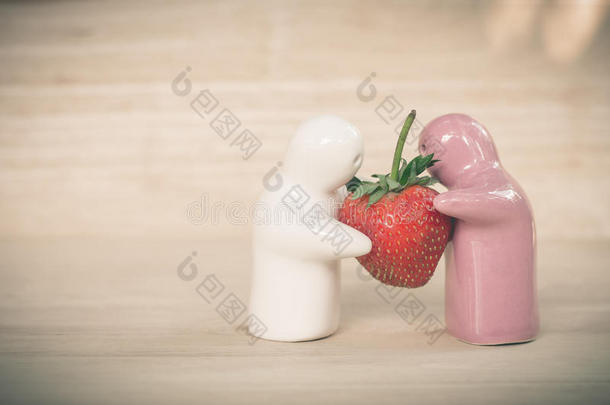 陶瓷玩具给一对夫妇一个草莓，<strong>因为</strong>他们的爱