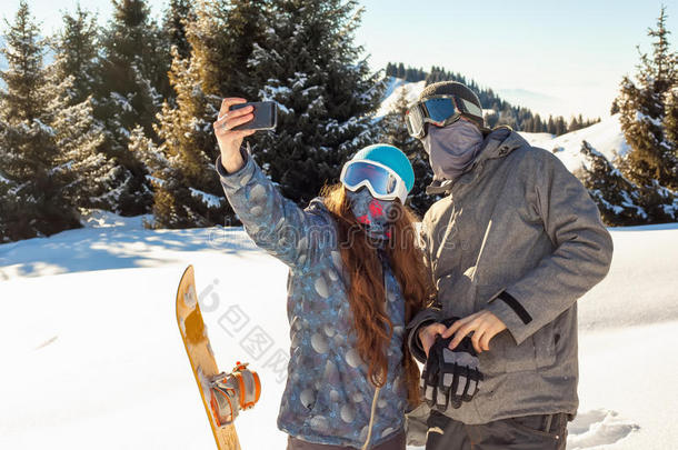 在日落时站在山顶上自拍的滑雪者