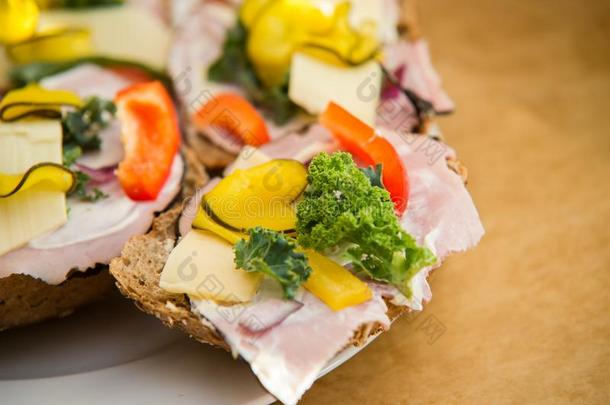 在新鲜的健康三明治上吃火腿、生菜、辣椒