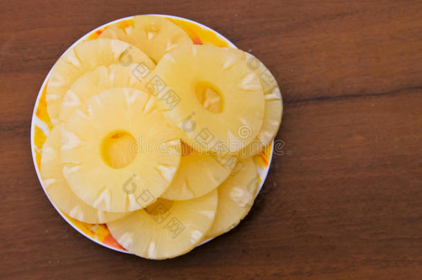 木制桌子上盘子里的菠萝罐头
