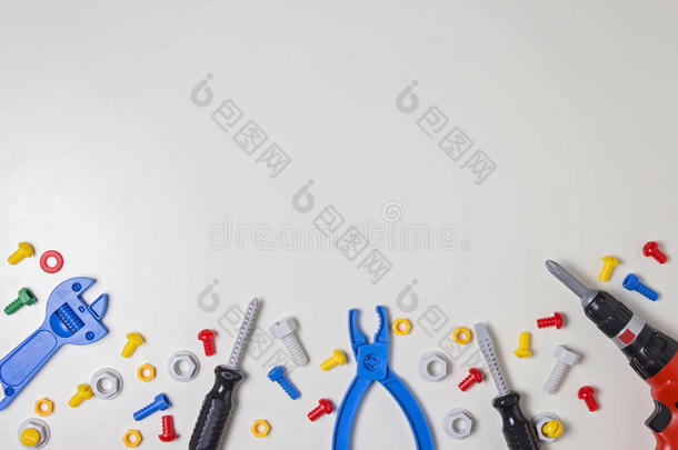 五颜六色的孩子玩具塑料螺栓，螺母，螺丝刀，钳子，钻头等建筑工具框架在白色