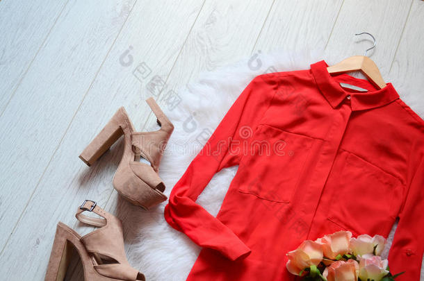 时尚概念。 红色衬衫和米色鞋在浅木背景上