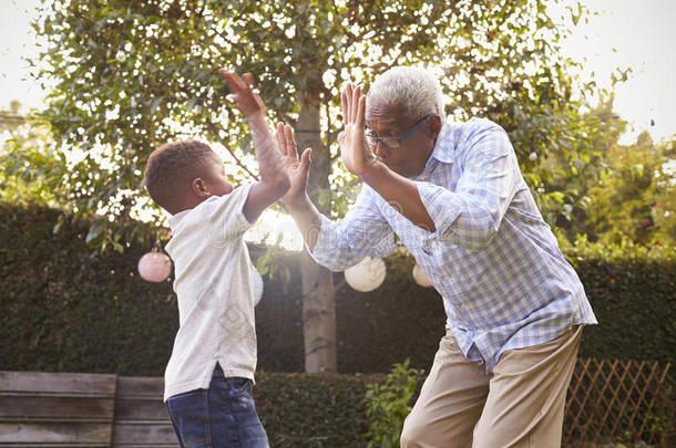 黑人祖父在花园里和他的孙子玩耍