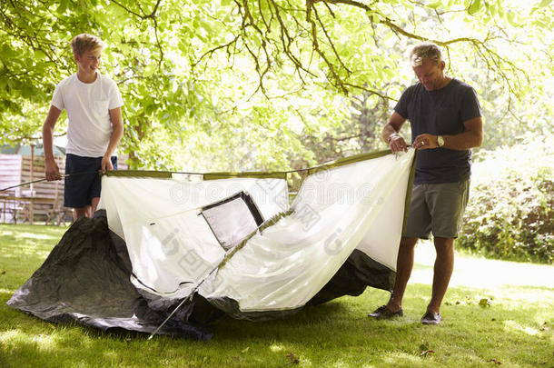 父亲和十几岁的儿子在野营旅行中搭帐篷