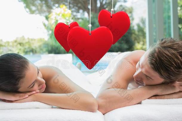 悬挂红心和情侣躺在水疗中心的复合图像