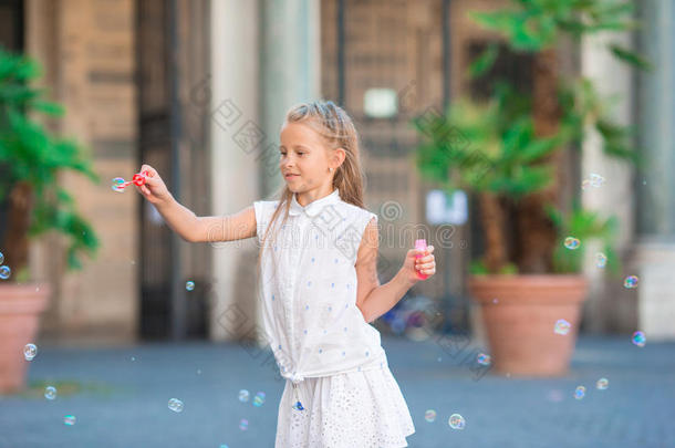 可爱的小女孩在欧洲城市吹肥皂泡。 白种人孩子的肖像在<strong>意</strong>大利享受<strong>暑</strong>假