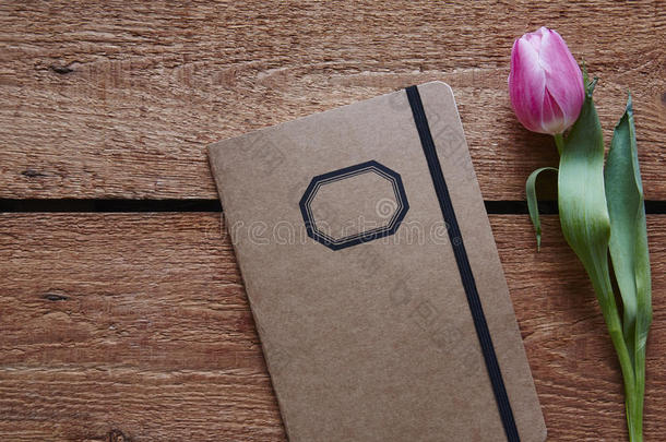 一个复古的笔记本和一个郁金香春天的气氛在木桌上
