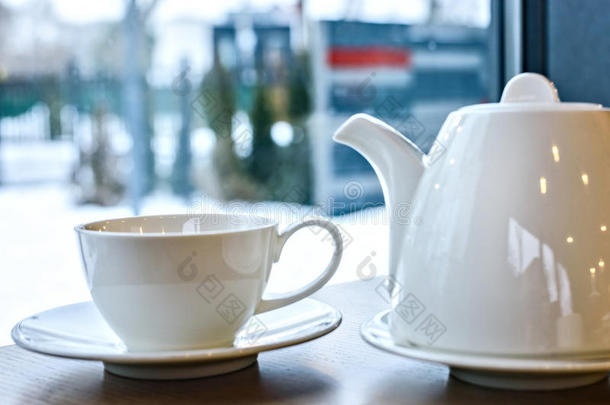餐厅里木桌上的一杯茶和茶壶