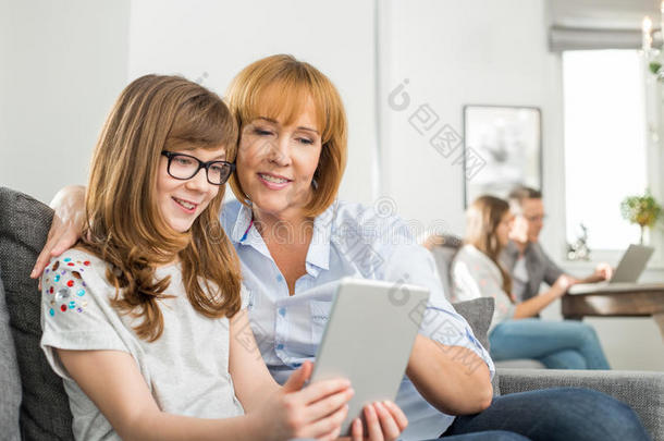 亲情母女用平板电脑，家人坐在家里
