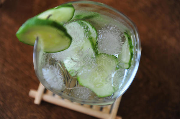 新鲜<strong>黄瓜</strong>夏季饮料在一个玻璃与冰在木桌上。 文本的自由空间
